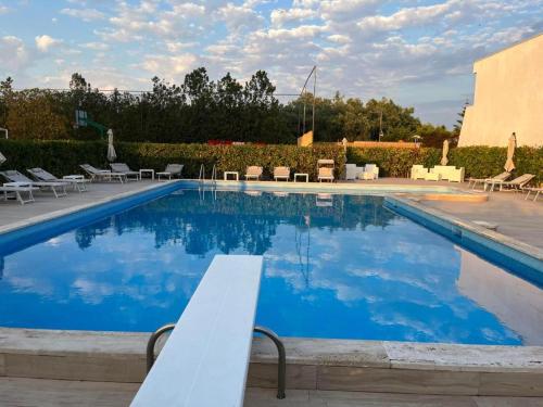 a large swimming pool with a white bench next to it at Residence Sunbeam in Leporano Marina