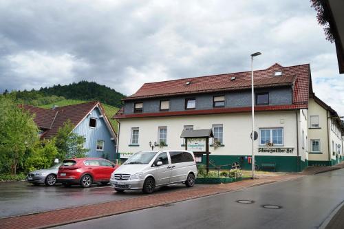 two cars parked in a parking lot in front of a building at Hotel Faxe Schwarzwälder Hof in Kappelrodeck