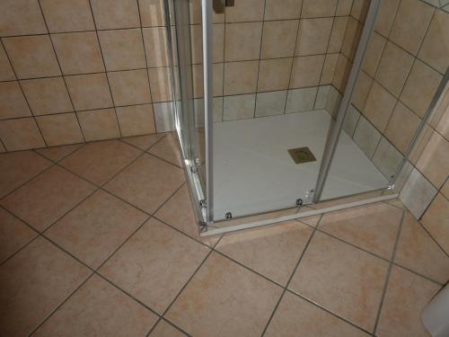 a shower with a glass door in a bathroom at B&B Oliena in Oliena