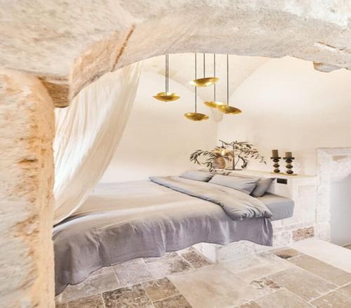 a bedroom with a bed in a stone wall at Bambarone La Masseria in Fasano
