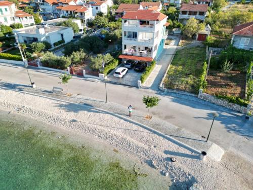 a person standing on the beach in front of a house at Villa Luce in Vinišće