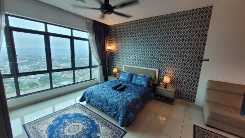 a bedroom with a bed with a blue comforter and large windows at MHA 26 EVO SUITE SOHO BANDAR BARU BANGI FREE NETFLIX N WIFI in Bandar Baru Bangi