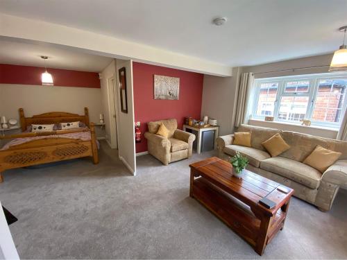 uma sala de estar com um sofá e uma cama em Crown & Anchor em Grantham