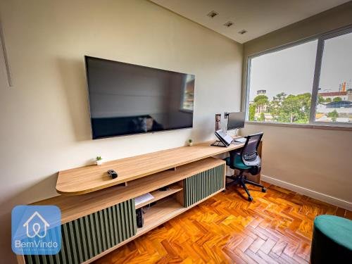 a room with a desk with a large flat screen tv at Apartamento Completo e Aconchegante no Centro in Salvador