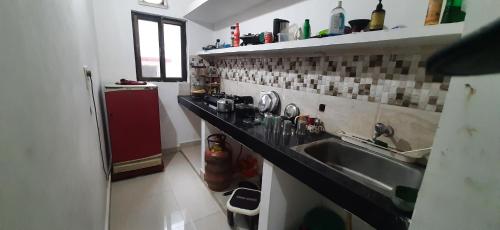 a kitchen with a sink and a red refrigerator at Kalawati Niwas in Bodh Gaya