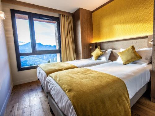 two beds in a hotel room with a large window at Appartement Les Arcs 1800, 4 pièces, 6 personnes - FR-1-352-85 in Bourg-Saint-Maurice