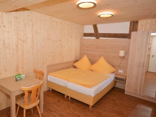 een kleine slaapkamer met een bed en een tafel bij Schneeglöckchen - a77330 in Colmberg