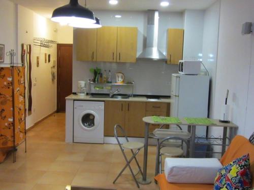 a small kitchen with a table and a refrigerator at 0318 Studio in Torremolinos 800 m from the beach in Torremolinos
