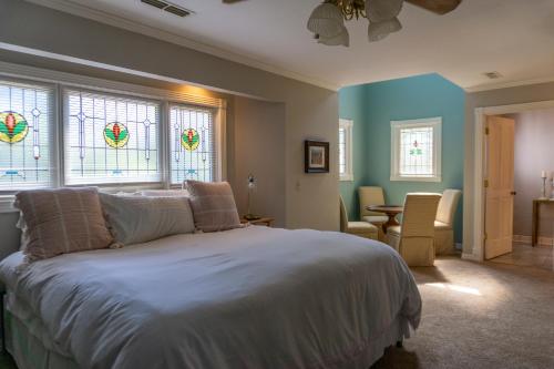 a bedroom with a bed and stained glass windows at Inn at Rose Hall in Eureka Springs