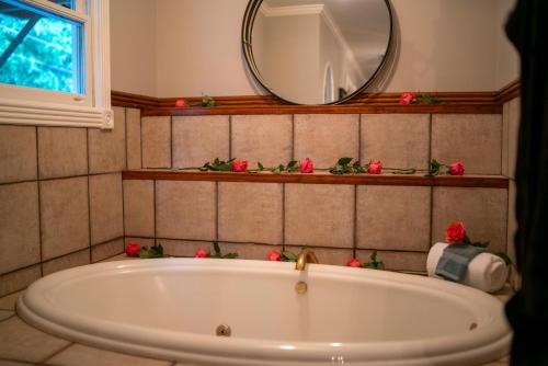 a bath tub in a bathroom with a mirror at Inn at Rose Hall in Eureka Springs