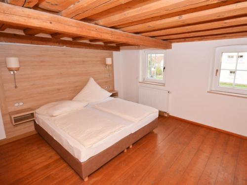 a bedroom with a bed in a room with wooden ceilings at Alte Schusterei in Colmberg