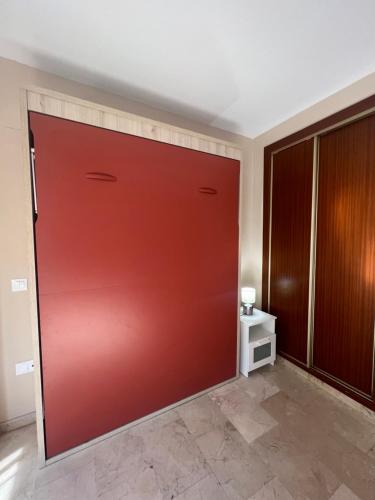 una puerta de garaje roja en una habitación en Wonderfull studio very close to the city center, en Málaga