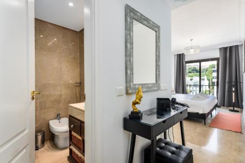 a bathroom with a bed and a desk with a mirror at Marina Real 2391 in Manilva