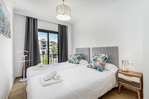 a bedroom with two beds and a window at Marina Real 2391 in Manilva