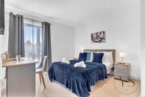 Habitación blanca con cama azul y escritorio. en Riverside Apartment 2BR - Parking - Wi-Fi -Netflix en Derby