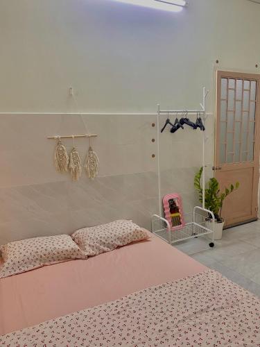 a bedroom with a bed with a pink comforter at Homestay Tuyết Trinh in Nha Trang