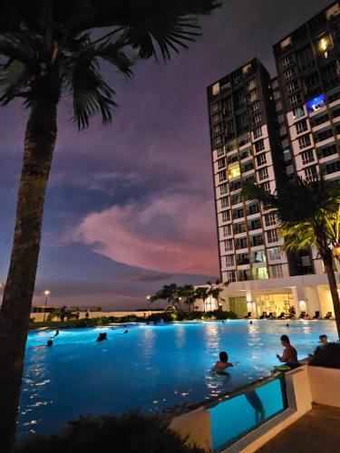 a pool with people swimming in it at night at METROPOL SERVICED APARTMENT at Bukit Mertajam, Pulau Pinang in Bukit Mertajam