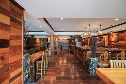a restaurant with wooden floors and wooden tables and chairs at Arbor's house and hostel in Chiang Mai