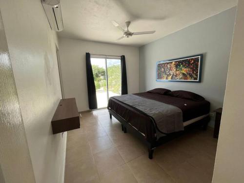 1 dormitorio con 1 cama y ventilador de techo en Hermosa casa, en Playa del Carmen