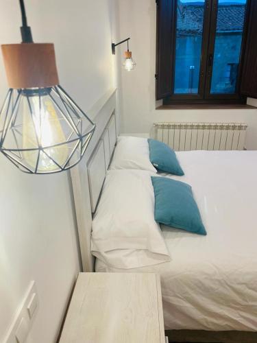 a bedroom with two beds with a lamp and a table at Apartamentos Rurales La Plaza 2 in Duruelo de la Sierra