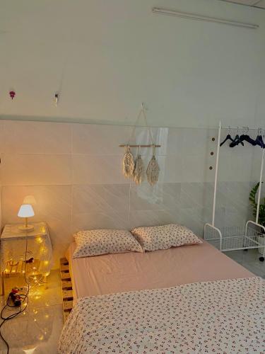 a bedroom with a bed and a table with a lamp at Homestay Tuyết Trinh in Nha Trang