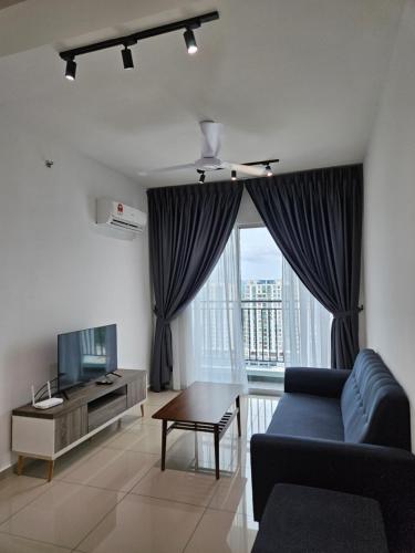 a living room with a blue couch and a tv at METROPOL SERVICED APARTMENT at Bukit Mertajam, Pulau Pinang in Bukit Mertajam