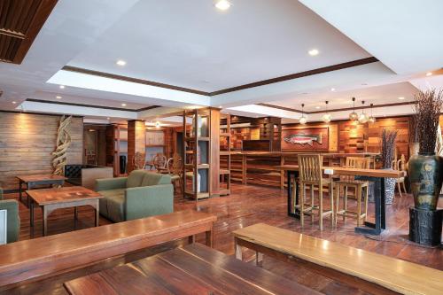 a restaurant with wooden floors and tables and chairs at Arbor's house and hostel in Chiang Mai