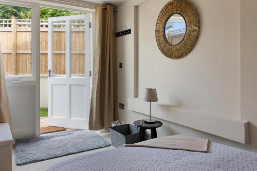 a bedroom with a bed and a mirror and a door at Captain's Retreat in Torquay
