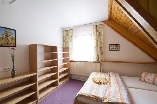 a attic bedroom with a bed and a window at Rodinný penzion Skiland in Ostružná