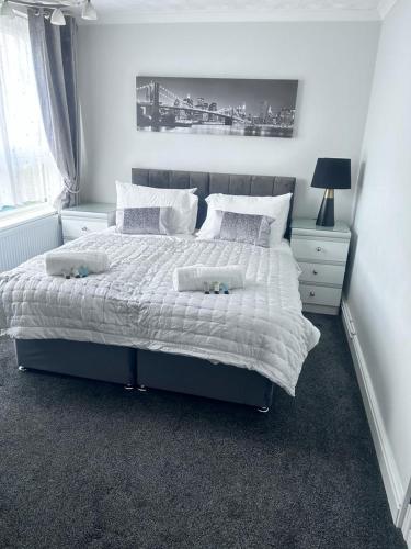 una camera da letto con un grande letto con lenzuola e cuscini bianchi di Parsonage Leys a Harlow