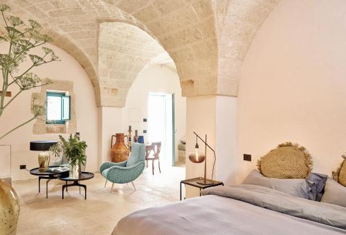 1 dormitorio con 1 cama, mesa y sillas en Bambarone La Masseria, en Fasano