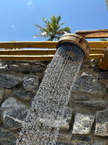 a water fountain attached to a stone wall at Kuarasy Pousada de Charme Japaratinga in Japaratinga