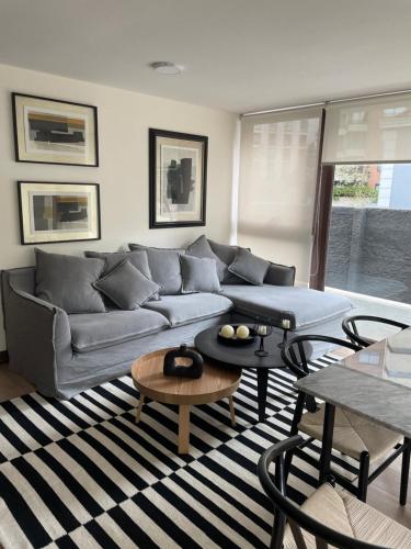 a living room with a couch and a table at AT HOME El Golf in Santiago