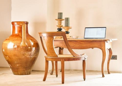 a desk with a laptop and a chair and a vase at Bambarone La Masseria in Fasano