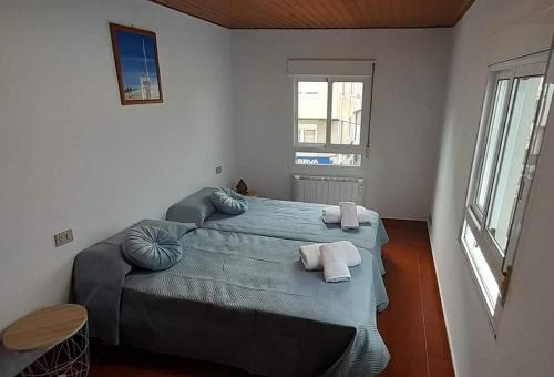 a bedroom with a large bed with towels on it at La Huella del Peregrino - Ionut Preda in Palas de Rei 