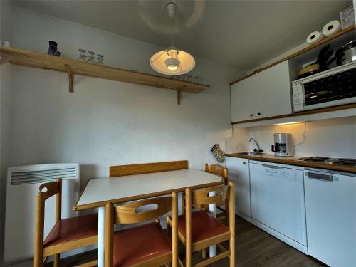 - une cuisine avec une table, des chaises et un comptoir dans l'établissement Charmant studio pour 3 pers. avec balcon, au pied des pistes, Reberty 2000 - FR-1-452-385, aux Menuires