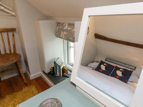 um pequeno quarto com um espelho sobre uma mesa em Puffins Nest em Bideford