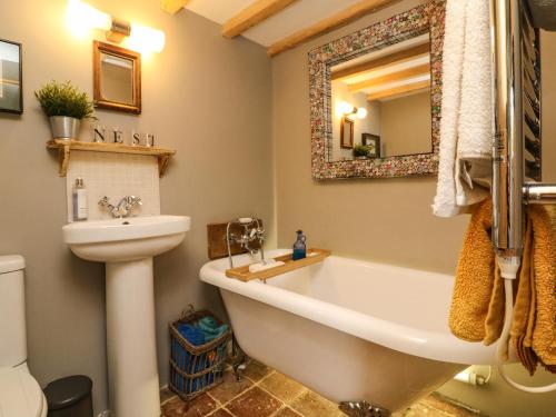 a bathroom with a tub and a toilet and a sink at Puffins Nest in Bideford