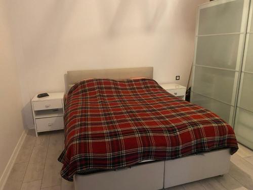 a bedroom with a bed with a plaid blanket on it at M House at Karsiyaka in Karşıyaka