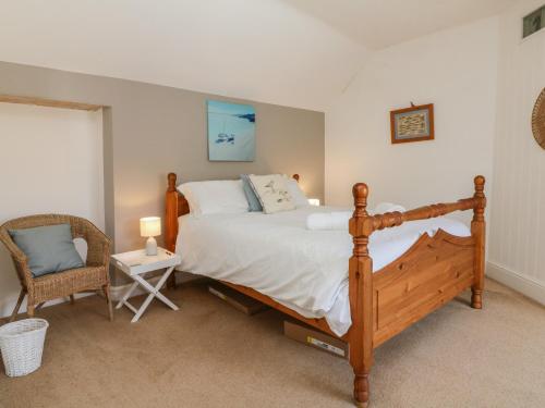- une chambre avec un grand lit et une chaise dans l'établissement Puffin House, à Bideford