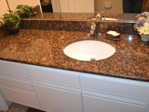 a bathroom sink with a granite counter top at Sweet retreat condo resort in Kissimmee
