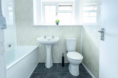 uma casa de banho branca com um WC e um lavatório em 2 Bed House near the London Museum em Londres