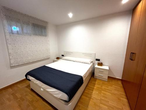 um quarto branco com uma cama e uma mesa de cabeceira em Elegante alojamiento con piscina y terraza em Valência