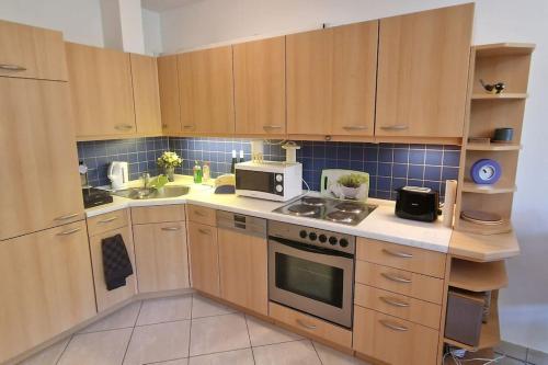 a kitchen with wooden cabinets and a stove top oven at Penthouse mit Moselblick in Traben-Trarbach