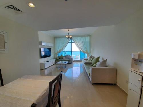 a living room with a table and a couch at Beachfront Holiday Homes in Ajman 