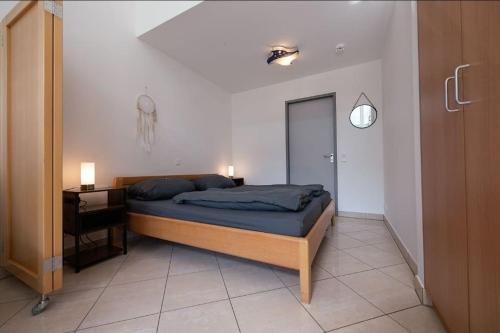 a bedroom with a bed and a desk and a door at Wohnwerk: Penthouse - Moselblick in Traben-Trarbach