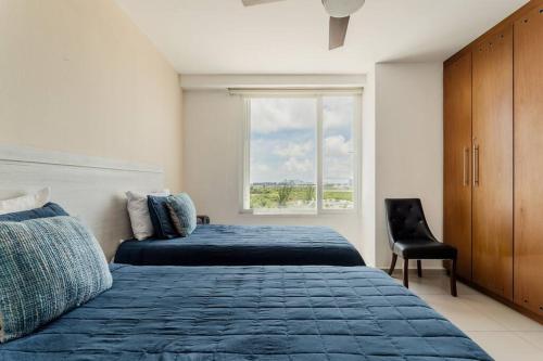 a bedroom with two beds and a window at REEF Beachfront 3BDR apartment by CASA PARAISO in Cancún
