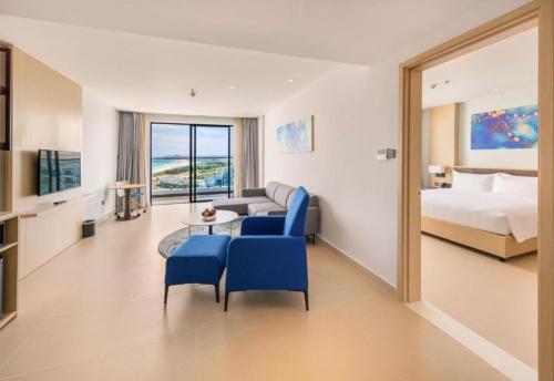 a hotel room with a bed and a couch and chairs at Ocean view at The Arena Cam Ranh resort, Bai Dai beach - near Airport Nha Trang, Khanh Hoa in Cam Lâm