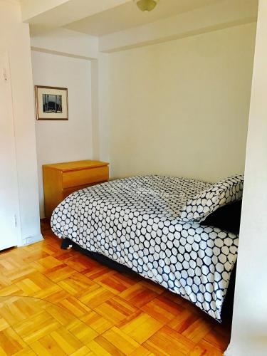 a bedroom with a bed and a wooden floor at Stylish Montreal Apartment: Comfortable Stay in the Golden Square Mile in Montreal