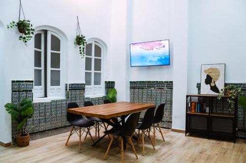uma sala de jantar com uma mesa de madeira e cadeiras em Triana Riverside Guesthouse em Sevilha